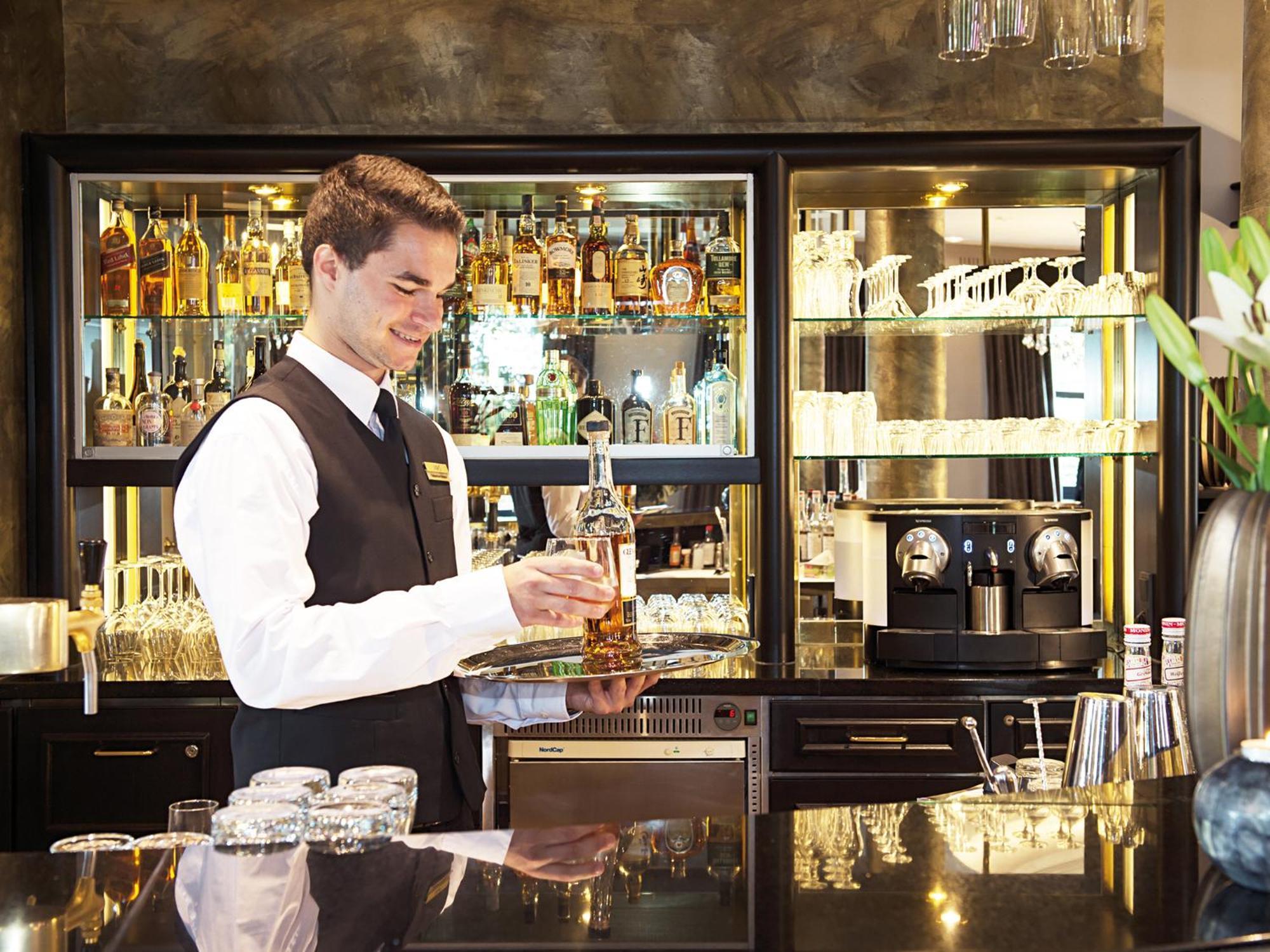 Victor'S Residenz-Hotel Schloss Berg Nennig Luaran gambar A bartender at work